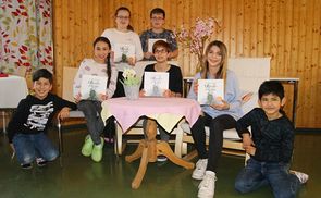 Anna Scheiblehner (li.) und Teresa Thalhammer mit den Kindern beim Vorlesetag im Caritas-Lerncafé Steyr.